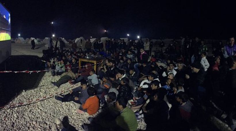 Πρόσφυγες και μετανάστες βλέπουν το «Μπαρτσελόνα – Ρεάλ» σε γιγαντοοθόνη