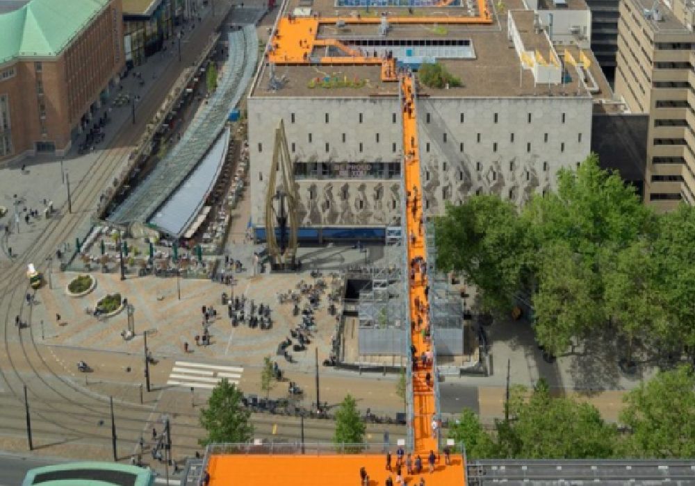 Ένας πορτοκαλί πεζόδρομος γεφυρώνει στέγες κτηρίων στο Ρότερνταμ