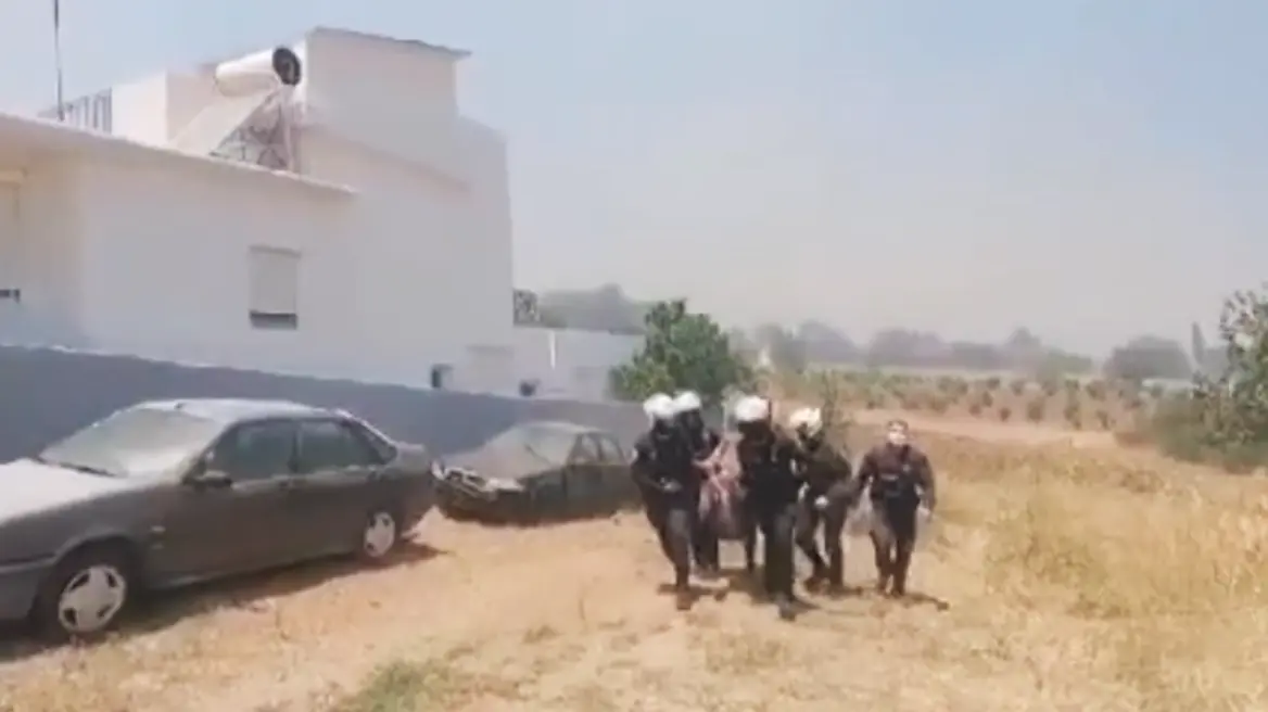 Φωτιά στην Κερατέα: Αστυνομικοί παίρνουν σηκωτή γυναίκα και απομακρύνουν φιάλες υγραερίου από σπίτι που έχει πάρει φωτιά (Video)